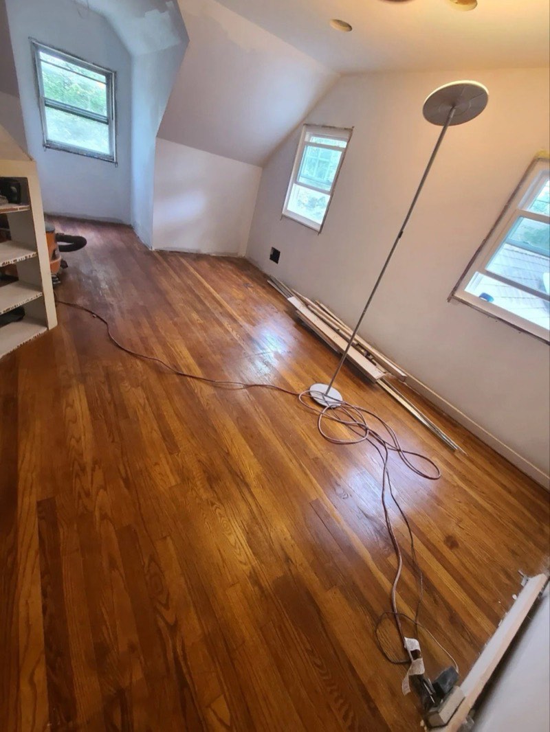 Refinished hardwood flooring in an attic room