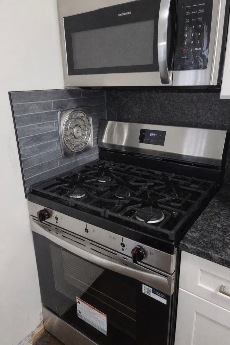Renovated kitchen with stainless steel appliances, granite counters, and tile backsplash